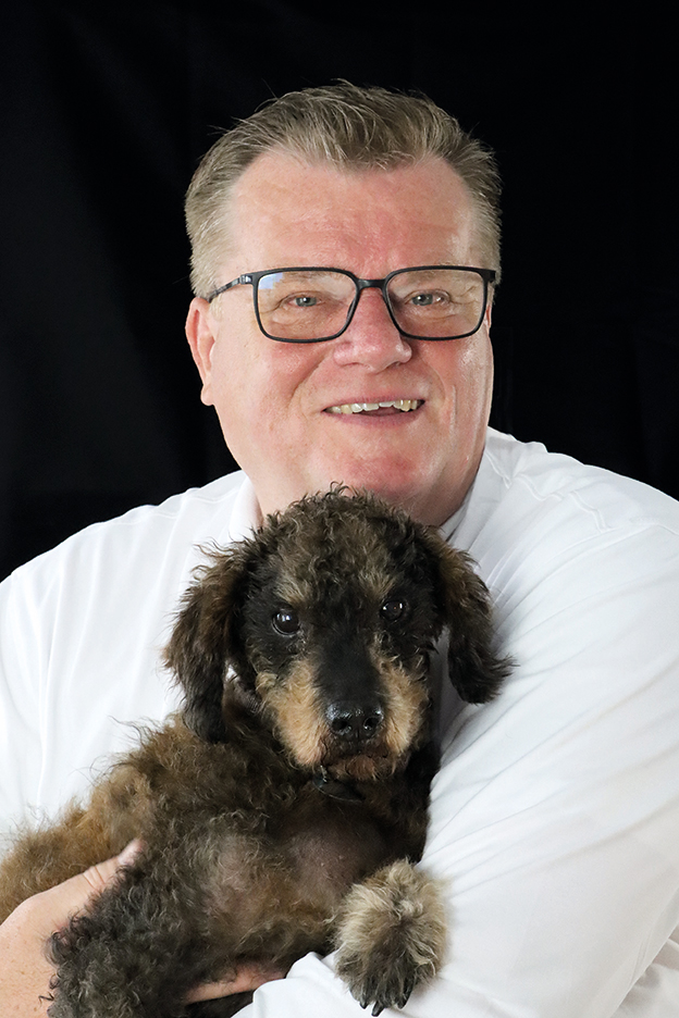 Portrait von Autor Thomas Schröder mit seinem Hund auf dem Arm