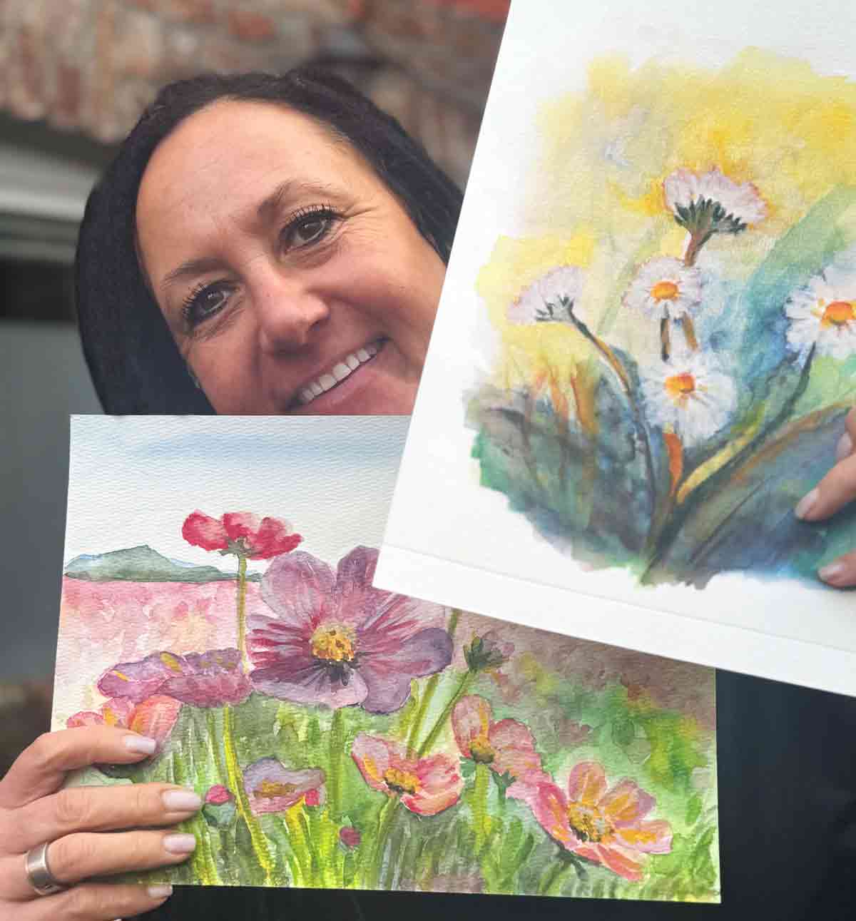 Nicole Manner zeigt zwei ihrer Aquarellbilder mit Blumenmotiven
