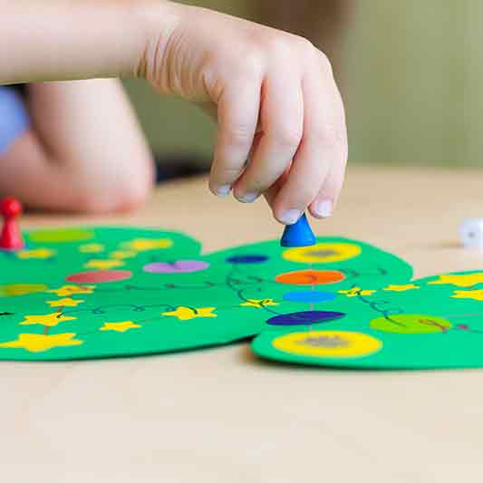Kinderhand spielt eine Spielfigur