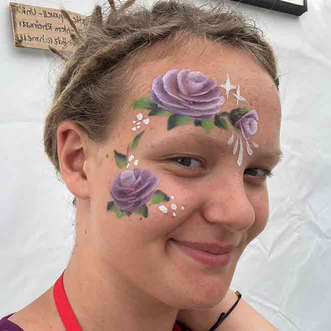 Portrait von Liv mit geschminkten Blumen im Gesicht